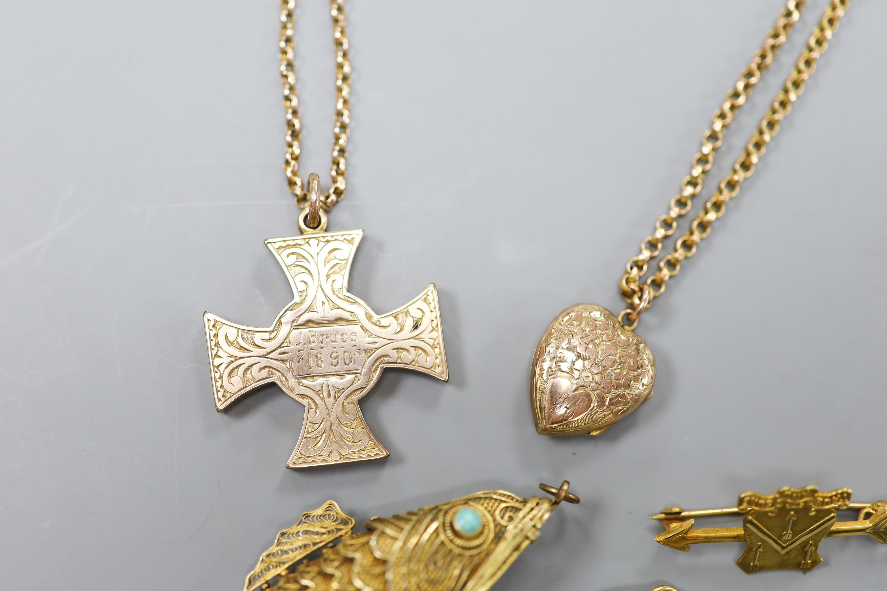 A Scottish yellow metal cross pendant on a 9c chain, a similar heart locket on a gilt metal chain, a Chinese 9k pendant brooch, a 9ct gold arrow brooch, a 9c chain(a.f.) and a filigree fish pendant